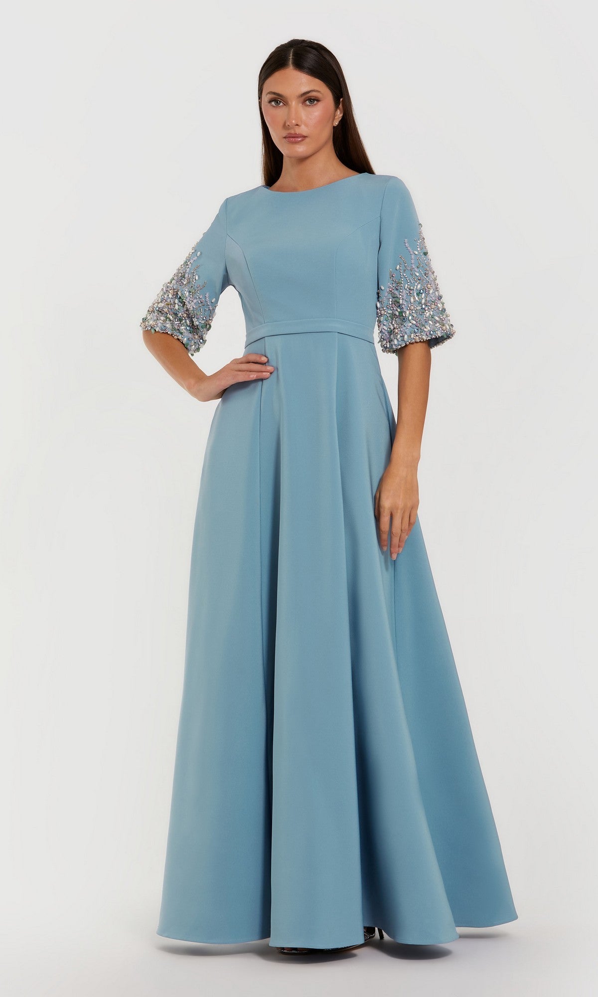 A woman poses against a white background in the Mac Duggal 2322 Long Formal Dress, featuring French Blue crepe fabric and beaded sleeve embellishments.